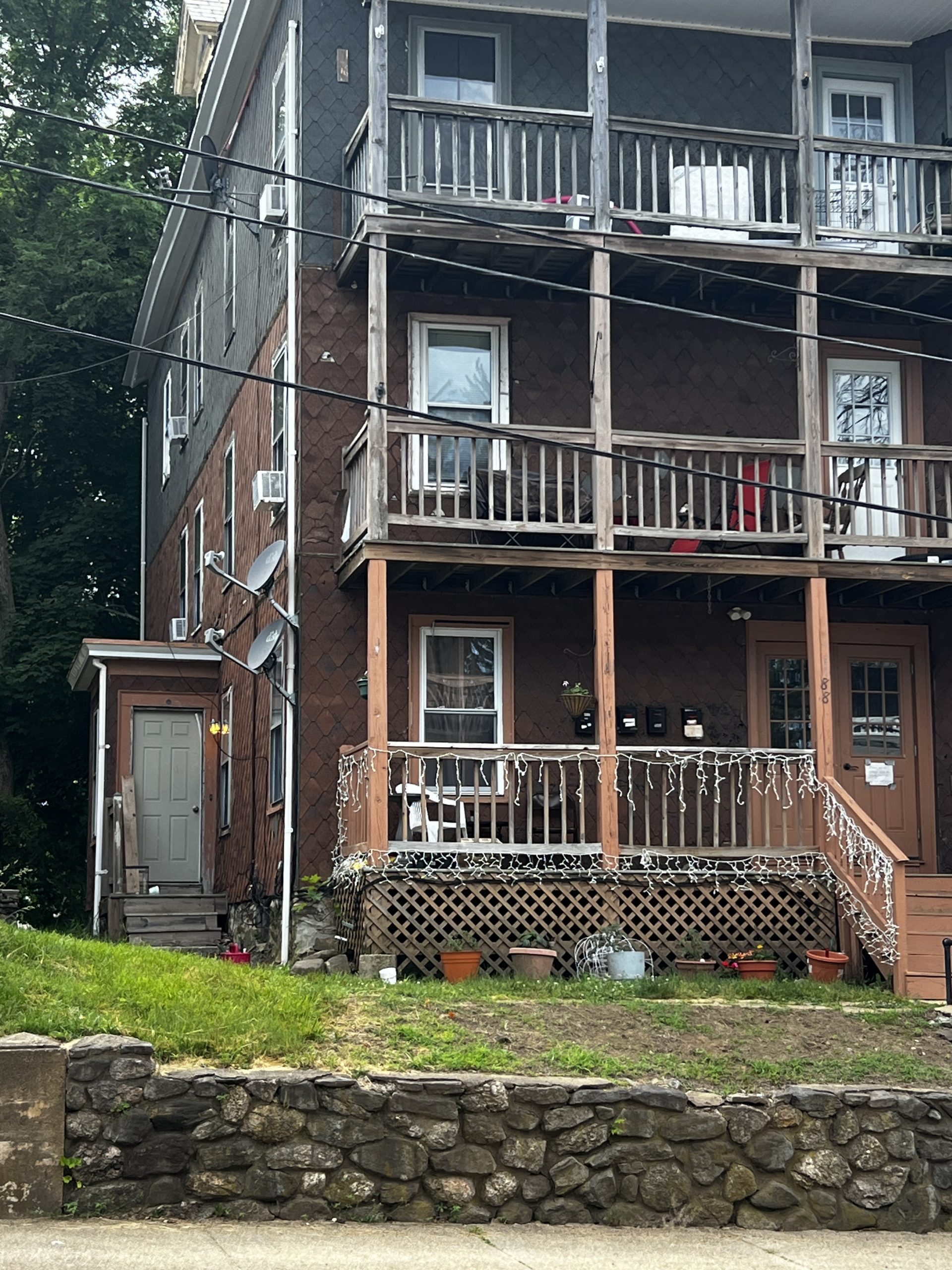 house with old asphalt shingle siding before remodeling